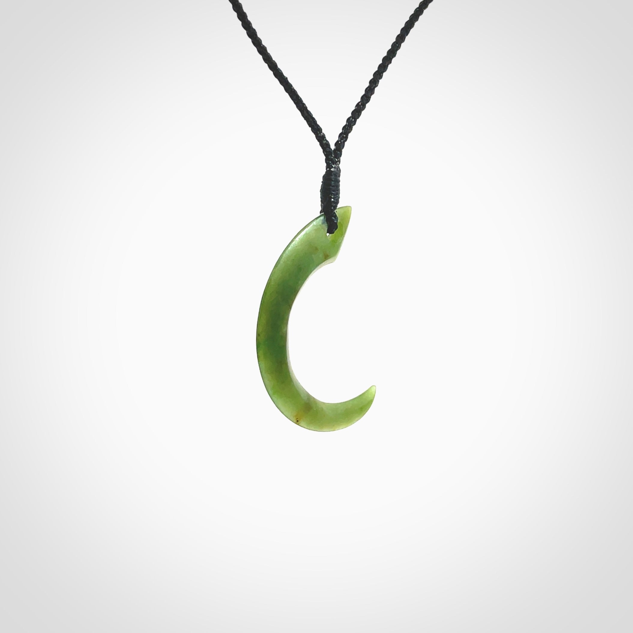 Hand carved pounamu drop pendant. Jade necklace hand made in New Zealand. A contemporary drop pendant carved from rare New Zealand jade. NZ Pacific jade jewellery for sale online. Provided with adjustable black cord and packaged in a woven kete pouch.