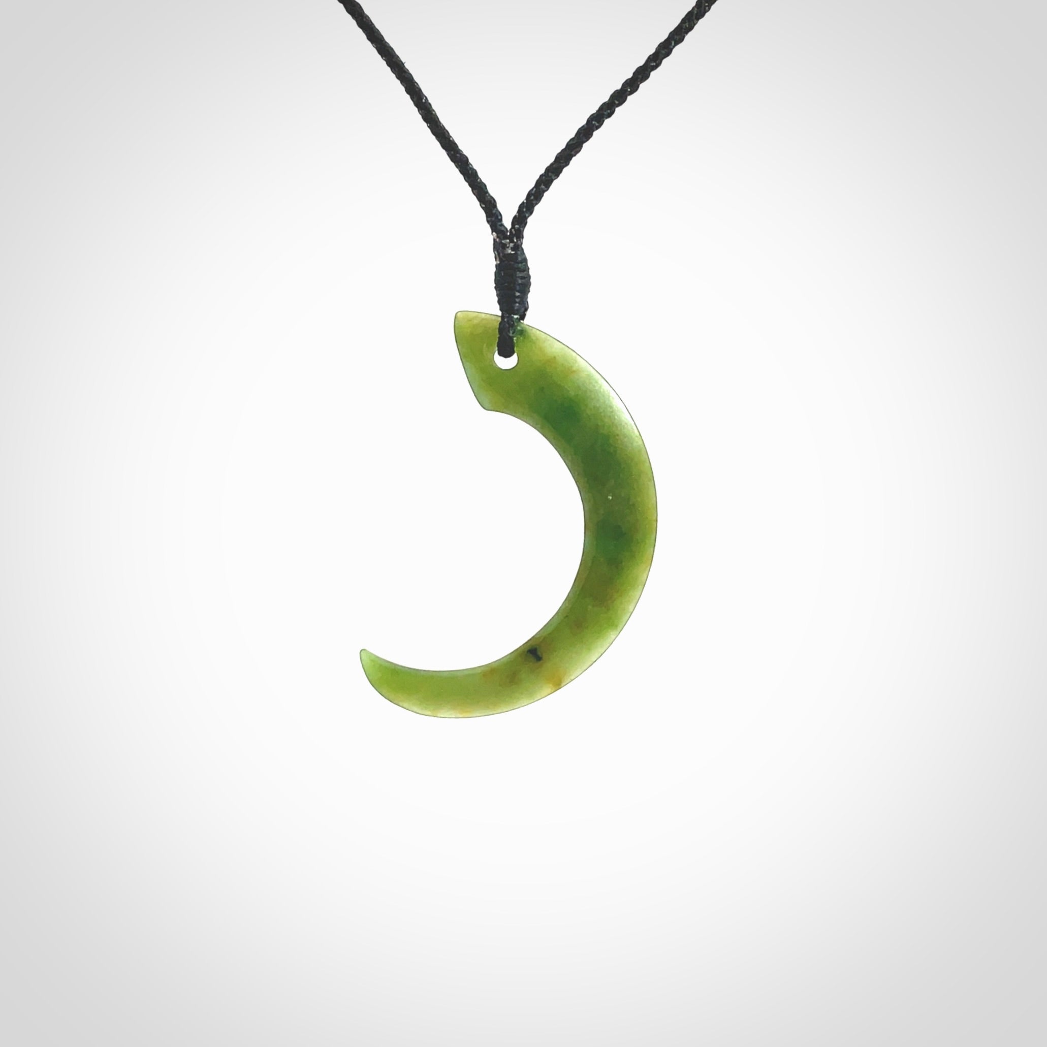 Hand carved pounamu drop pendant. Jade necklace hand made in New Zealand. A contemporary drop pendant carved from rare New Zealand jade. NZ Pacific jade jewellery for sale online. Provided with adjustable black cord and packaged in a woven kete pouch.