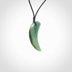 This is a lovely New Zealand Jade, pounamu drop pendant. Hand carved for us by Ric Moor. It is bound with an adjustable black cord which is length adjustable. Free worldwide shipping. The light reveals the internal structure and colour of the stone beautifully.