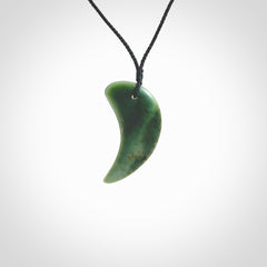 This is a lovely New Zealand Jade, pounamu drop pendant. Hand carved for us by Ric Moor. It is bound with an adjustable black cord which is length adjustable. Free worldwide shipping. The light reveals the internal structure and colour of the stone beautifully.