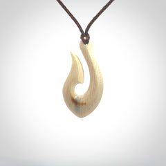 Hand carved ancient woolly mammoth tusk hook necklace with adjustable cord. Mammoth Tusk stabilised with blue resin pendant. Unique medium sized hook necklaces hand made from woolly mammoth tusk. Real ancient mammoth tusk delivered in a woven kete pouch.