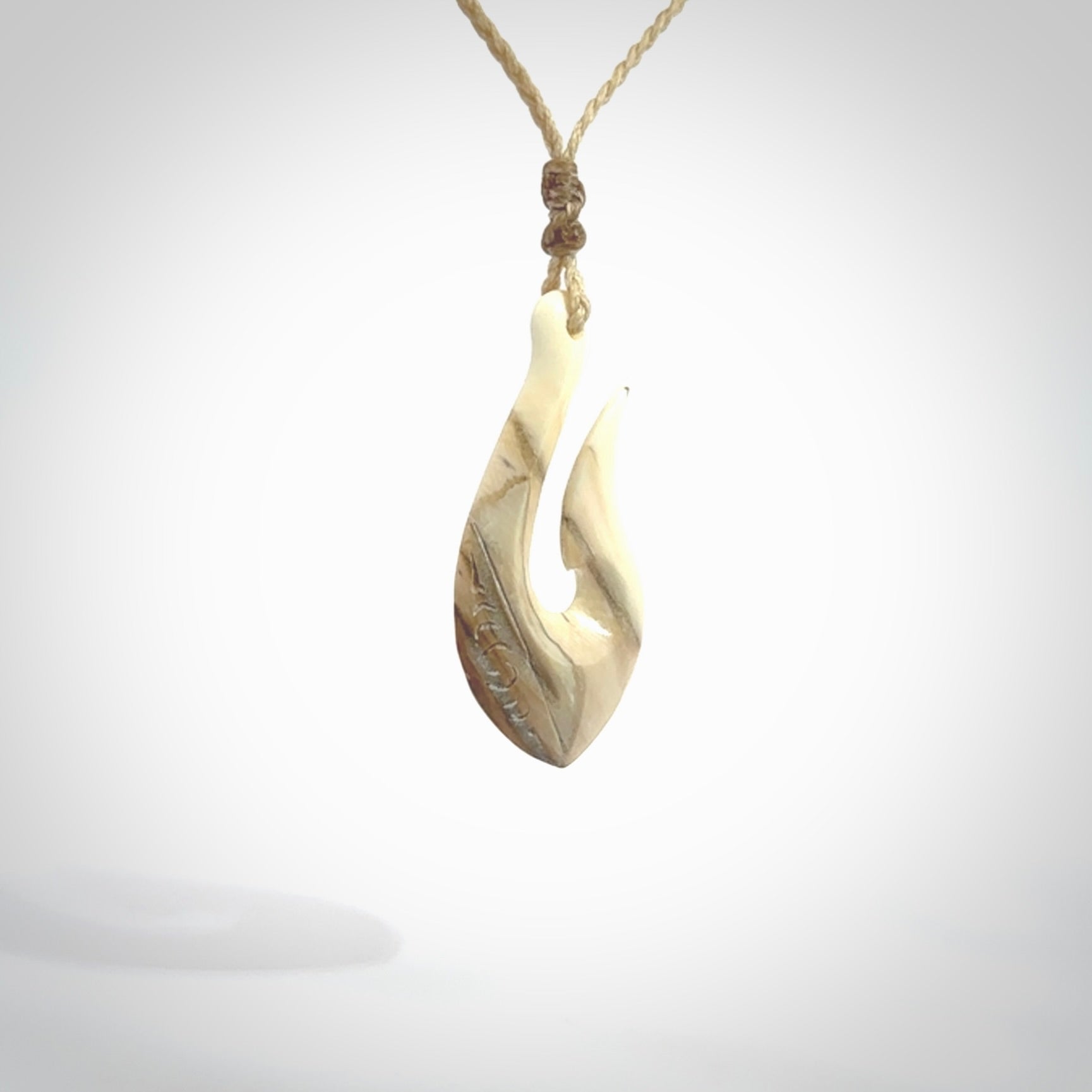 Hand carved ancient woolly mammoth tusk hook necklace with adjustable cord. Mammoth Tusk stabilised with blue resin pendant. Unique medium sized hook necklaces hand made from woolly mammoth tusk. Real ancient mammoth tusk delivered in a woven kete pouch.