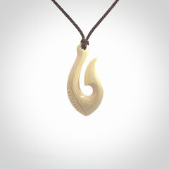 Hand carved ancient woolly mammoth tusk hook necklace with adjustable cord. Mammoth Tusk stabilised with blue resin pendant. Unique medium sized hook necklaces hand made from woolly mammoth tusk. Real ancient mammoth tusk delivered in a woven kete pouch.