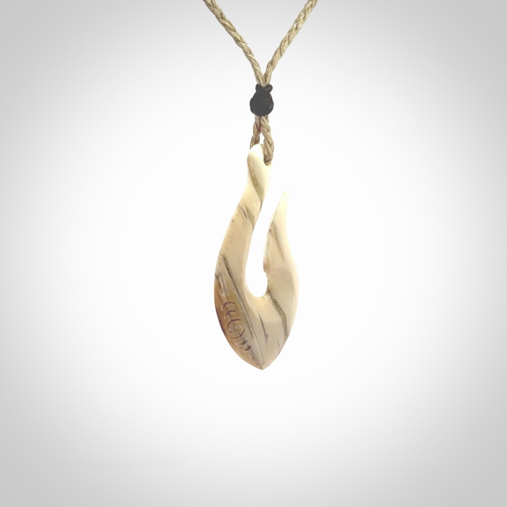 Hand carved ancient woolly mammoth tusk hook necklace with adjustable cord. Mammoth Tusk stabilised with blue resin pendant. Unique medium sized hook necklaces hand made from woolly mammoth tusk. Real ancient mammoth tusk delivered in a woven kete pouch.