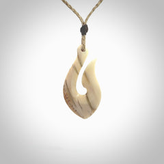 Hand carved ancient woolly mammoth tusk hook necklace with adjustable cord. Mammoth Tusk stabilised with blue resin pendant. Unique medium sized hook necklaces hand made from woolly mammoth tusk. Real ancient mammoth tusk delivered in a woven kete pouch.