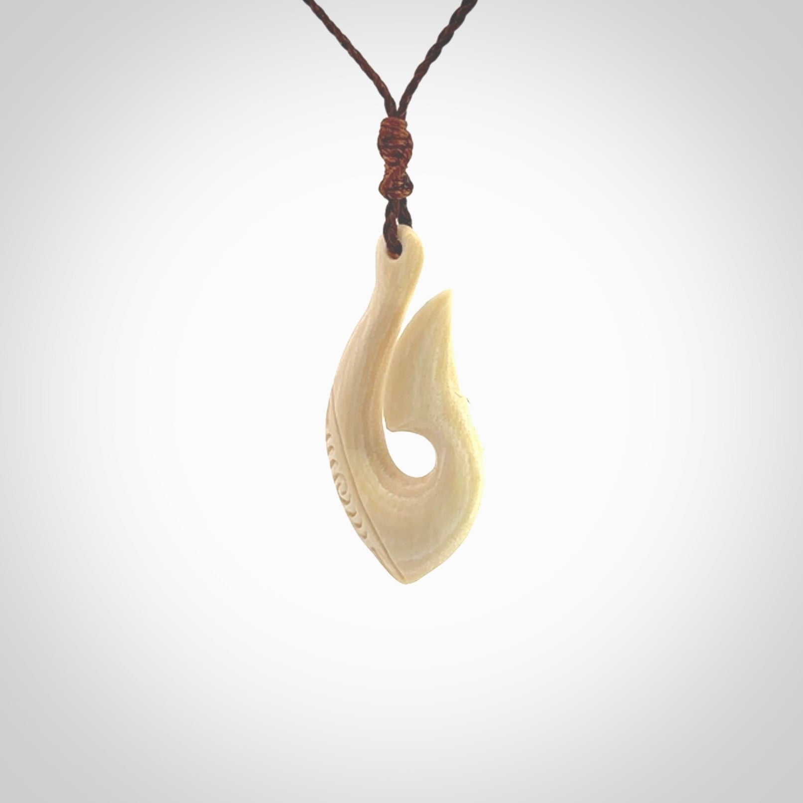 Hand carved ancient woolly mammoth tusk hook necklace with adjustable cord. Mammoth Tusk stabilised with blue resin pendant. Unique medium sized hook necklaces hand made from woolly mammoth tusk. Real ancient mammoth tusk delivered in a woven kete pouch.