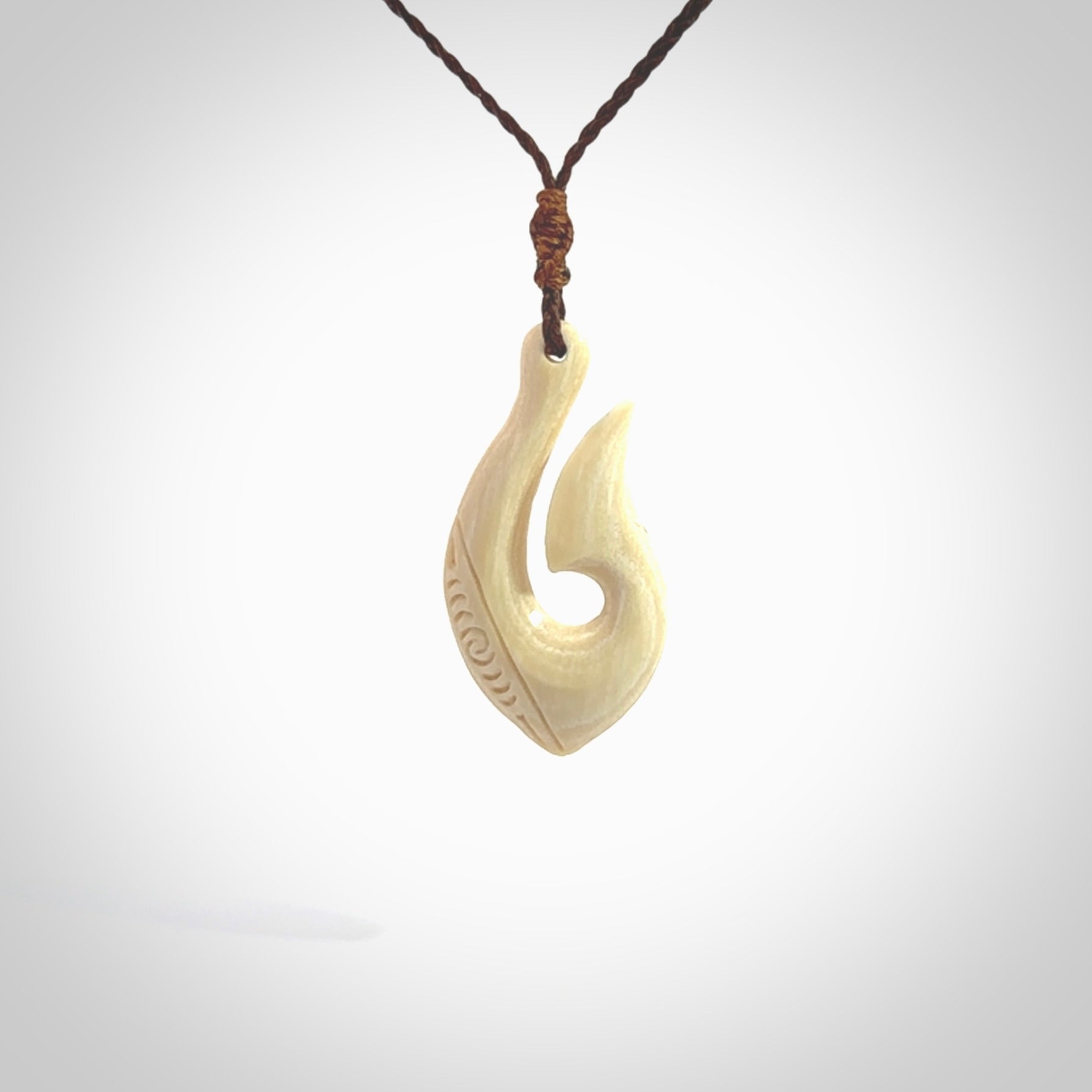 Hand carved ancient woolly mammoth tusk hook necklace with adjustable cord. Mammoth Tusk stabilised with blue resin pendant. Unique medium sized hook necklaces hand made from woolly mammoth tusk. Real ancient mammoth tusk delivered in a woven kete pouch.