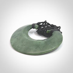 Hand carved New Zealand Jade chest plate pendant. Made by Ana Krakosky for NZ Pacific in New Zealand Pounamu, jade. A beautiful light green jade chest plate drop necklace with black adjustable cord.