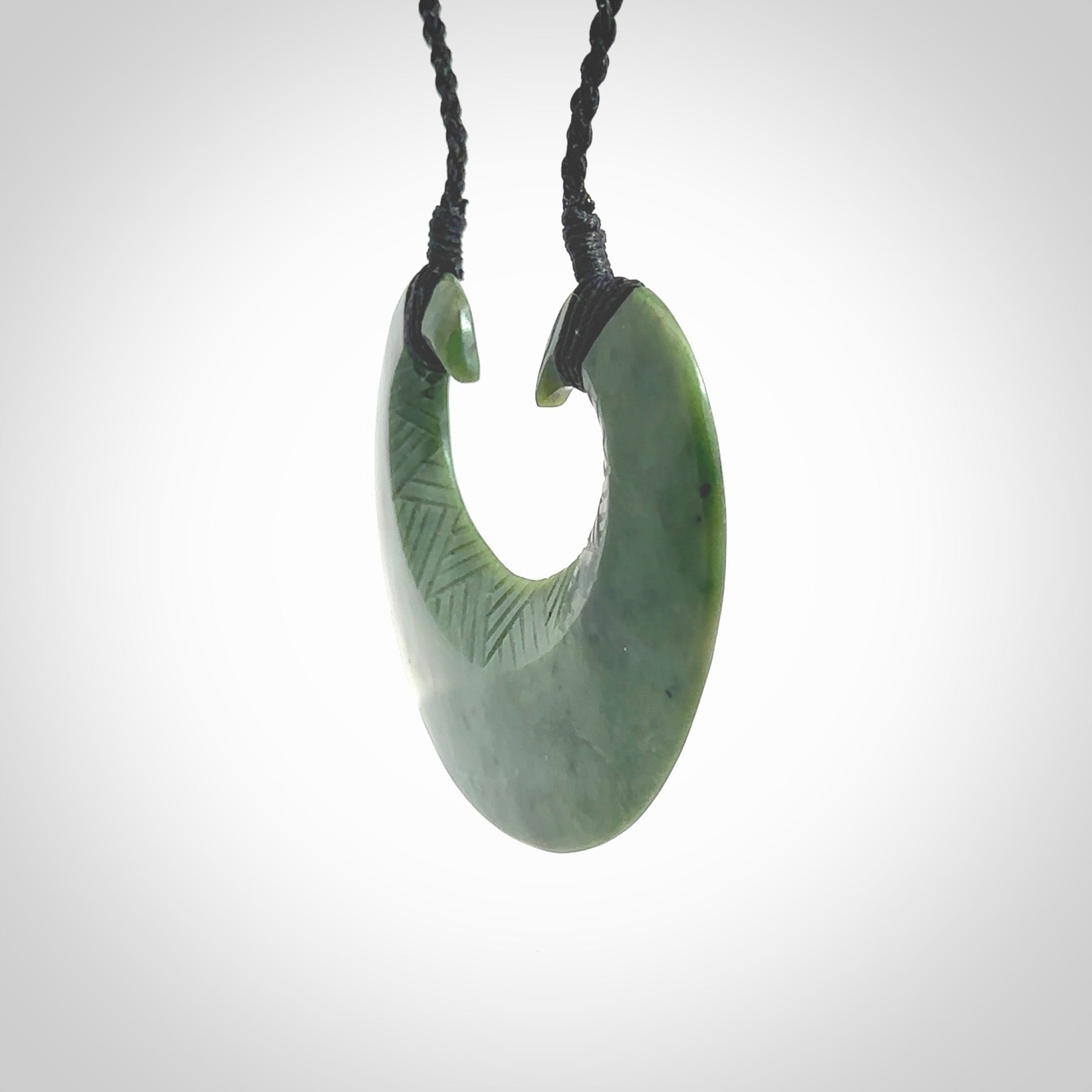 Hand carved New Zealand Jade chest plate pendant. Made by Ana Krakosky for NZ Pacific in New Zealand Pounamu, jade. A beautiful light green jade chest plate drop necklace with black adjustable cord.