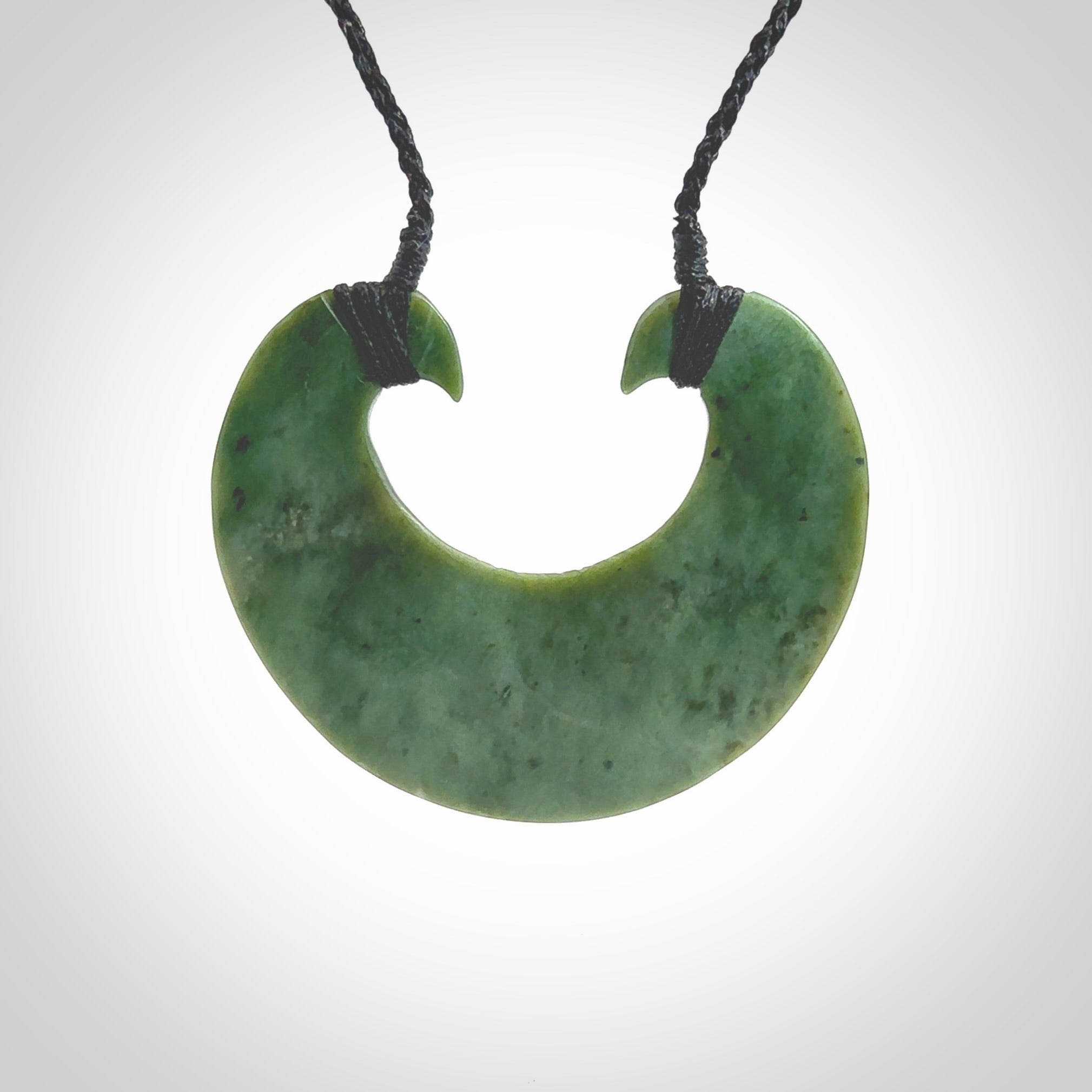 Hand carved New Zealand Jade chest plate pendant. Made by Ana Krakosky for NZ Pacific in New Zealand Pounamu, jade. A beautiful light green jade chest plate drop necklace with black adjustable cord.