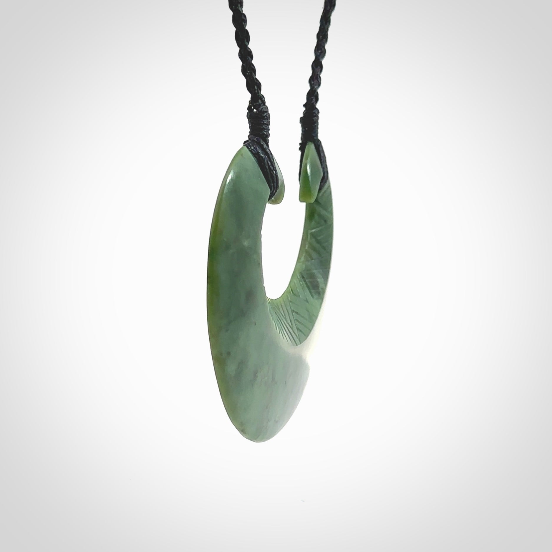 Hand carved New Zealand Jade chest plate pendant. Made by Ana Krakosky for NZ Pacific in New Zealand Pounamu, jade. A beautiful light green jade chest plate drop necklace with black adjustable cord.