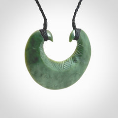 Hand carved New Zealand Jade chest plate pendant. Made by Ana Krakosky for NZ Pacific in New Zealand Pounamu, jade. A beautiful light green jade chest plate drop necklace with black adjustable cord.