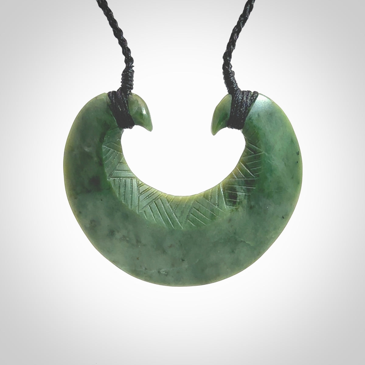 Hand carved New Zealand Jade chest plate pendant. Made by Ana Krakosky for NZ Pacific in New Zealand Pounamu, jade. A beautiful light green jade chest plate drop necklace with black adjustable cord.