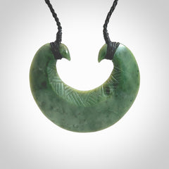 Hand carved New Zealand Jade chest plate pendant. Made by Ana Krakosky for NZ Pacific in New Zealand Pounamu, jade. A beautiful light green jade chest plate drop necklace with black adjustable cord.