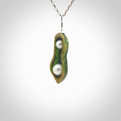 Hand carved New Zealand Marsden Jade two peas in a pod drop pendant with two pearl inlays. Made by Ana Krakosky for NZ Pacific in New Zealand Pounamu, flower jade with real pearls. A beautiful dark green and orange jade representing two peas in a pod. A drop with pearl inserts necklace with long sterling silver chain. One only, provided in a wooden gift box and delivered with express courier.