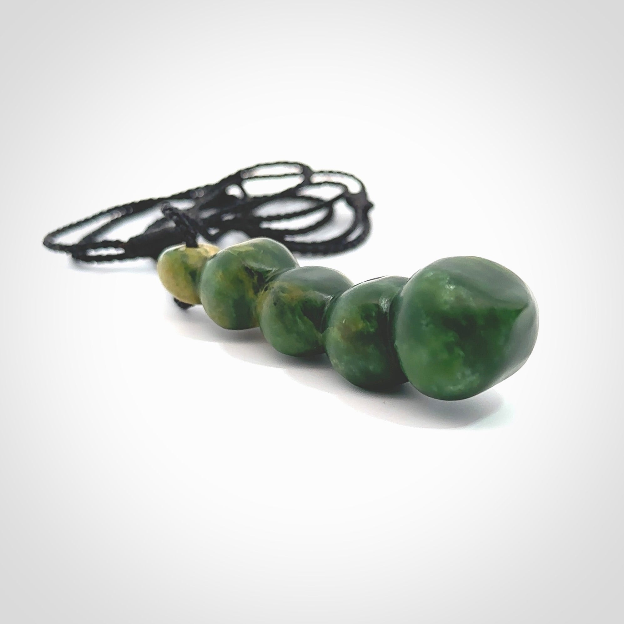 Hand carved New Zealand flower Jade beads drop pendant. Made by Ana Krakosky for NZ Pacific in New Zealand Pounamu, jade. A beautiful orange and green jade beads necklace with black adjustable cord. Large beads necklace carved in flower Jade.