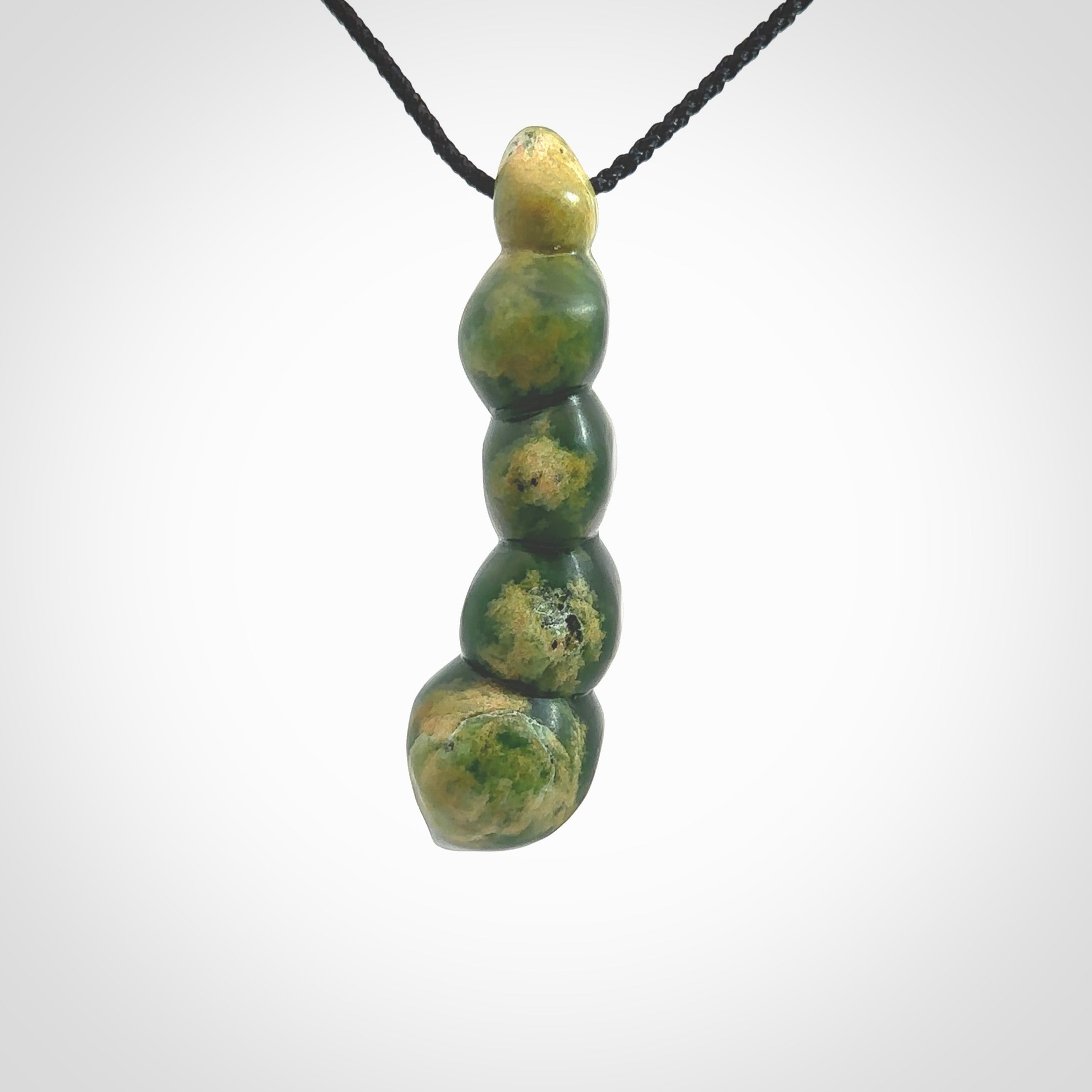 Hand carved New Zealand flower Jade beads drop pendant. Made by Ana Krakosky for NZ Pacific in New Zealand Pounamu, jade. A beautiful orange and green jade beads necklace with black adjustable cord. Large beads necklace carved in flower Jade.