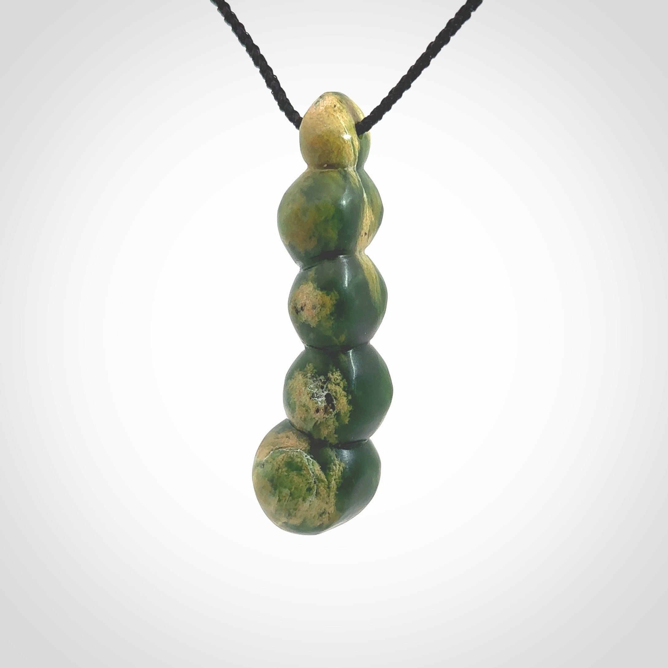 Hand carved New Zealand flower Jade beads drop pendant. Made by Ana Krakosky for NZ Pacific in New Zealand Pounamu, jade. A beautiful orange and green jade beads necklace with black adjustable cord. Large beads necklace carved in flower Jade.