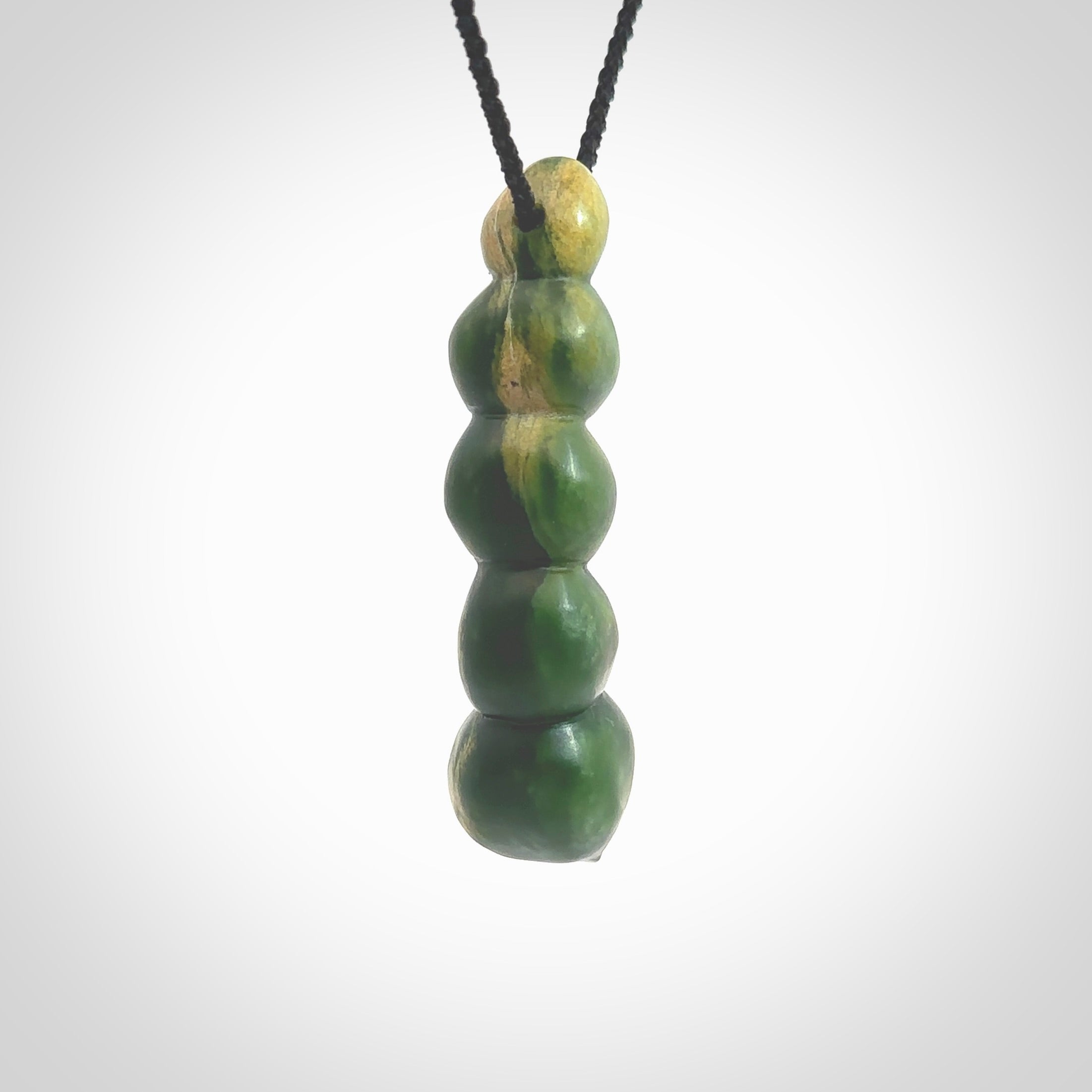 Hand carved New Zealand flower Jade beads drop pendant. Made by Ana Krakosky for NZ Pacific in New Zealand Pounamu, jade. A beautiful orange and green jade beads necklace with black adjustable cord. Large beads necklace carved in flower Jade.