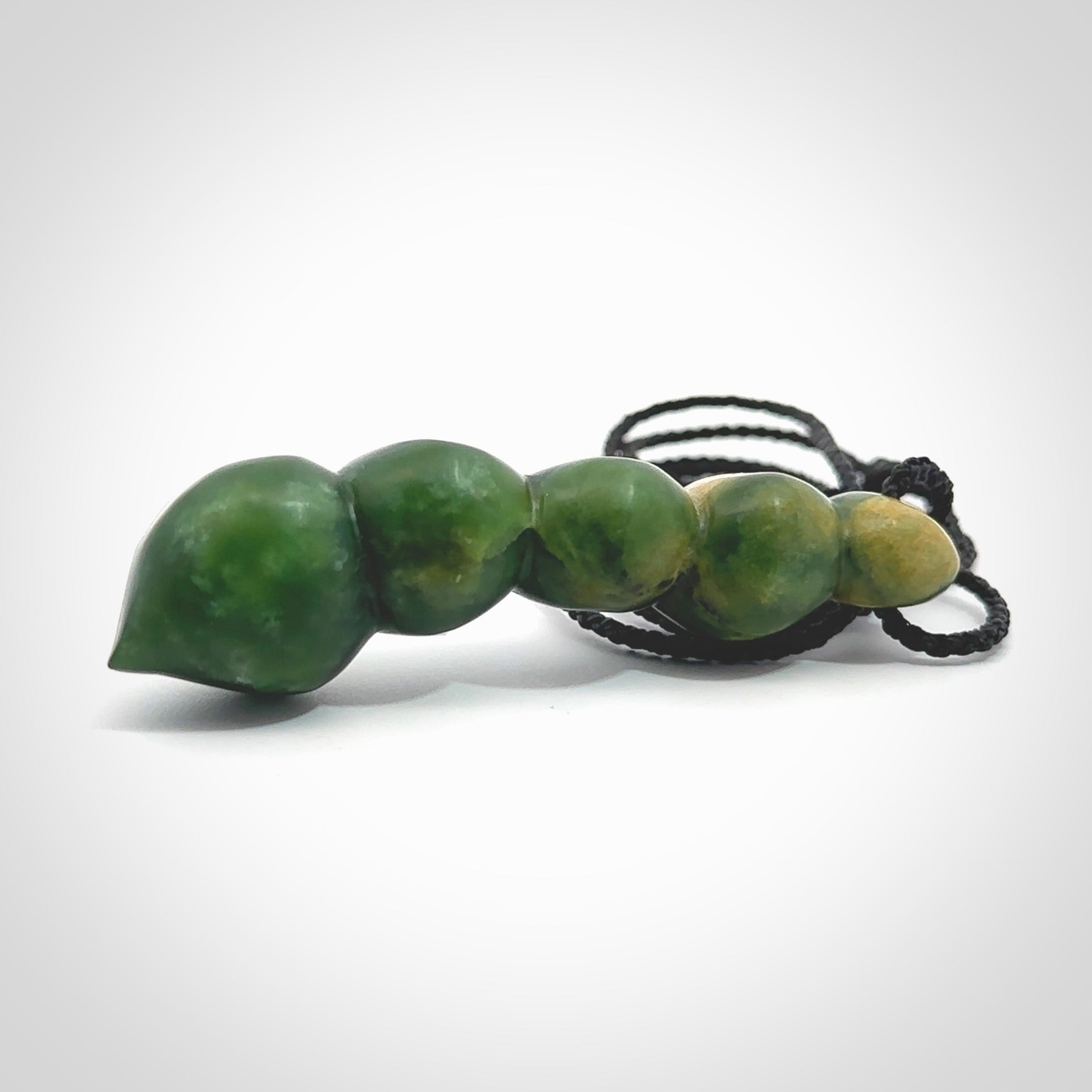 Hand carved New Zealand flower Jade beads drop pendant. Made by Ana Krakosky for NZ Pacific in New Zealand Pounamu, jade. A beautiful orange and green jade beads necklace with black adjustable cord. Large beads necklace carved in flower Jade.