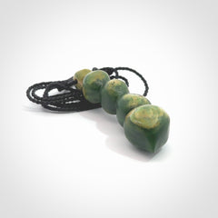 Hand carved New Zealand flower Jade beads drop pendant. Made by Ana Krakosky for NZ Pacific in New Zealand Pounamu, jade. A beautiful orange and green jade beads necklace with black adjustable cord. Large beads necklace carved in flower Jade.