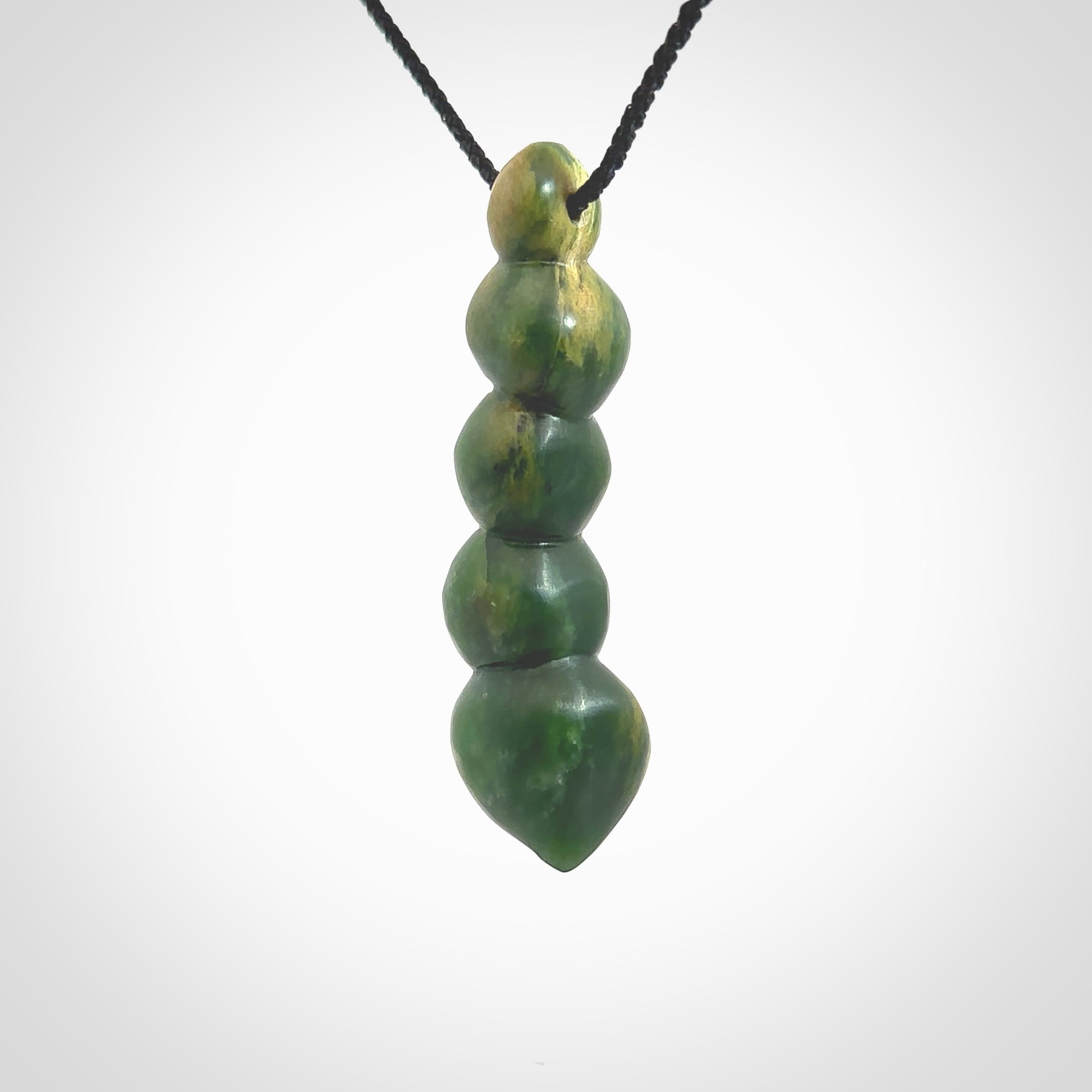 Hand carved New Zealand flower Jade beads drop pendant. Made by Ana Krakosky for NZ Pacific in New Zealand Pounamu, jade. A beautiful orange and green jade beads necklace with black adjustable cord. Large beads necklace carved in flower Jade.