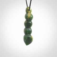 Hand carved New Zealand flower Jade beads drop pendant. Made by Ana Krakosky for NZ Pacific in New Zealand Pounamu, jade. A beautiful orange and green jade beads necklace with black adjustable cord. Large beads necklace carved in flower Jade.