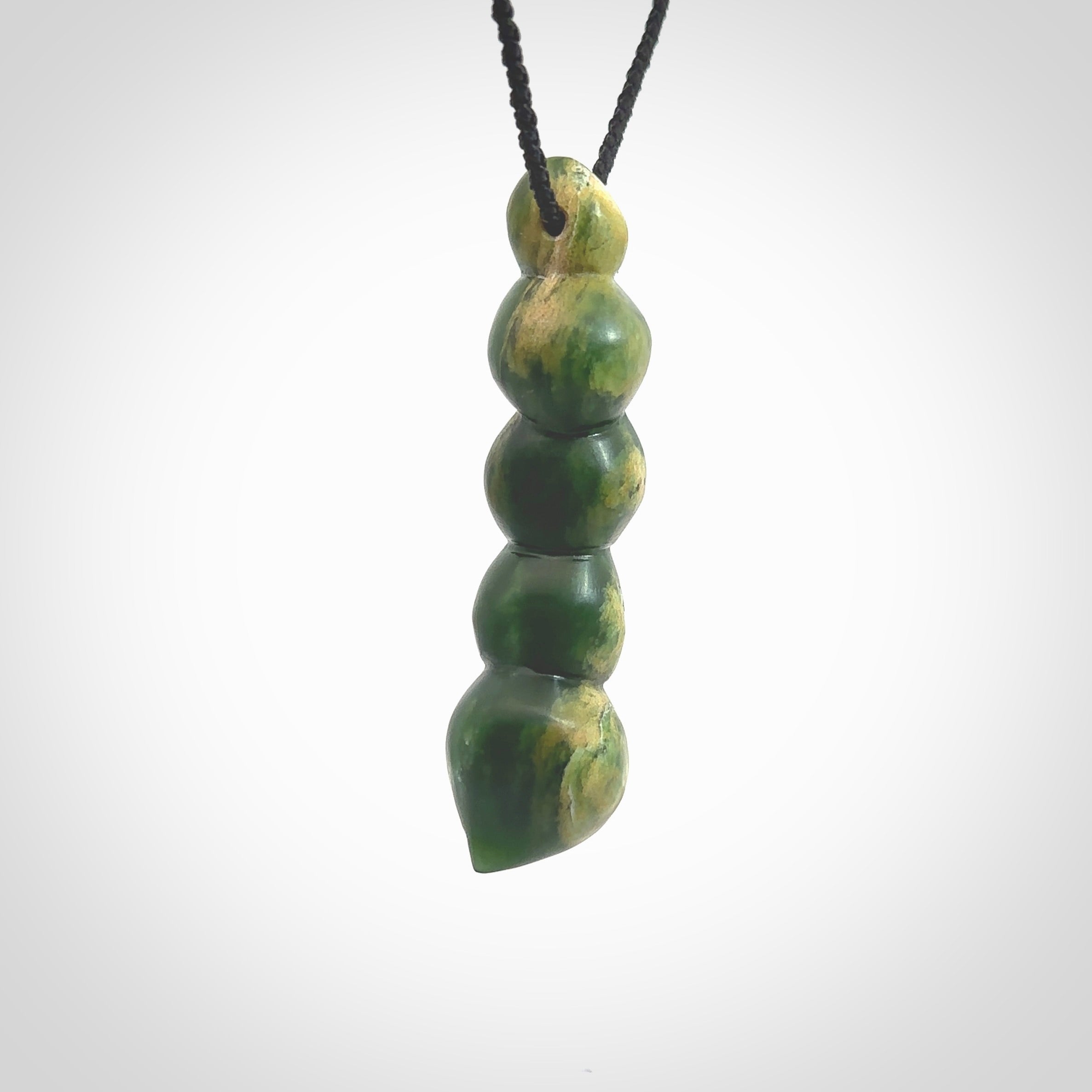 Hand carved New Zealand flower Jade beads drop pendant. Made by Ana Krakosky for NZ Pacific in New Zealand Pounamu, jade. A beautiful orange and green jade beads necklace with black adjustable cord. Large beads necklace carved in flower Jade.