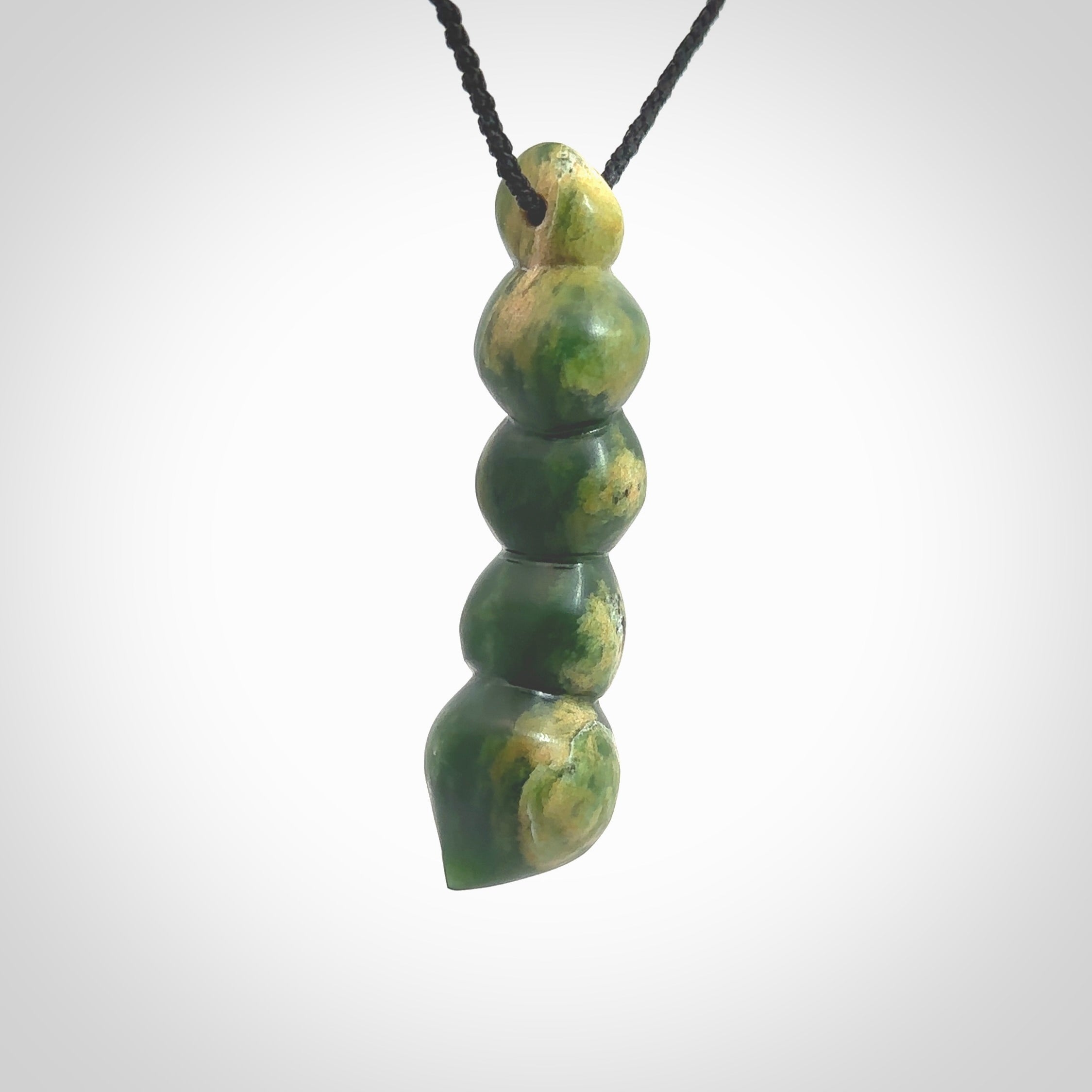 Hand carved New Zealand flower Jade beads drop pendant. Made by Ana Krakosky for NZ Pacific in New Zealand Pounamu, jade. A beautiful orange and green jade beads necklace with black adjustable cord. Large beads necklace carved in flower Jade.