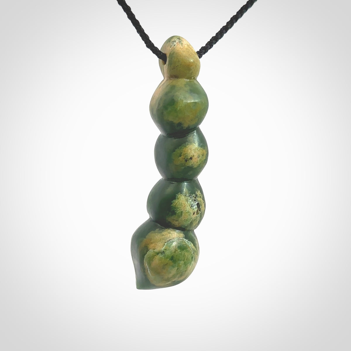 Hand carved New Zealand flower Jade beads drop pendant. Made by Ana Krakosky for NZ Pacific in New Zealand Pounamu, jade. A beautiful orange and green jade beads necklace with black adjustable cord. Large beads necklace carved in flower Jade.