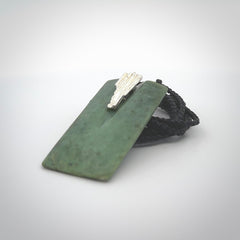 A charismatic pendant carved from New Zealand Pounamu. This is a medium sized, rectangle drop with a silver cast shard inlay on the front. Hand made by wonderful artist and carver; Ana Krakosky.