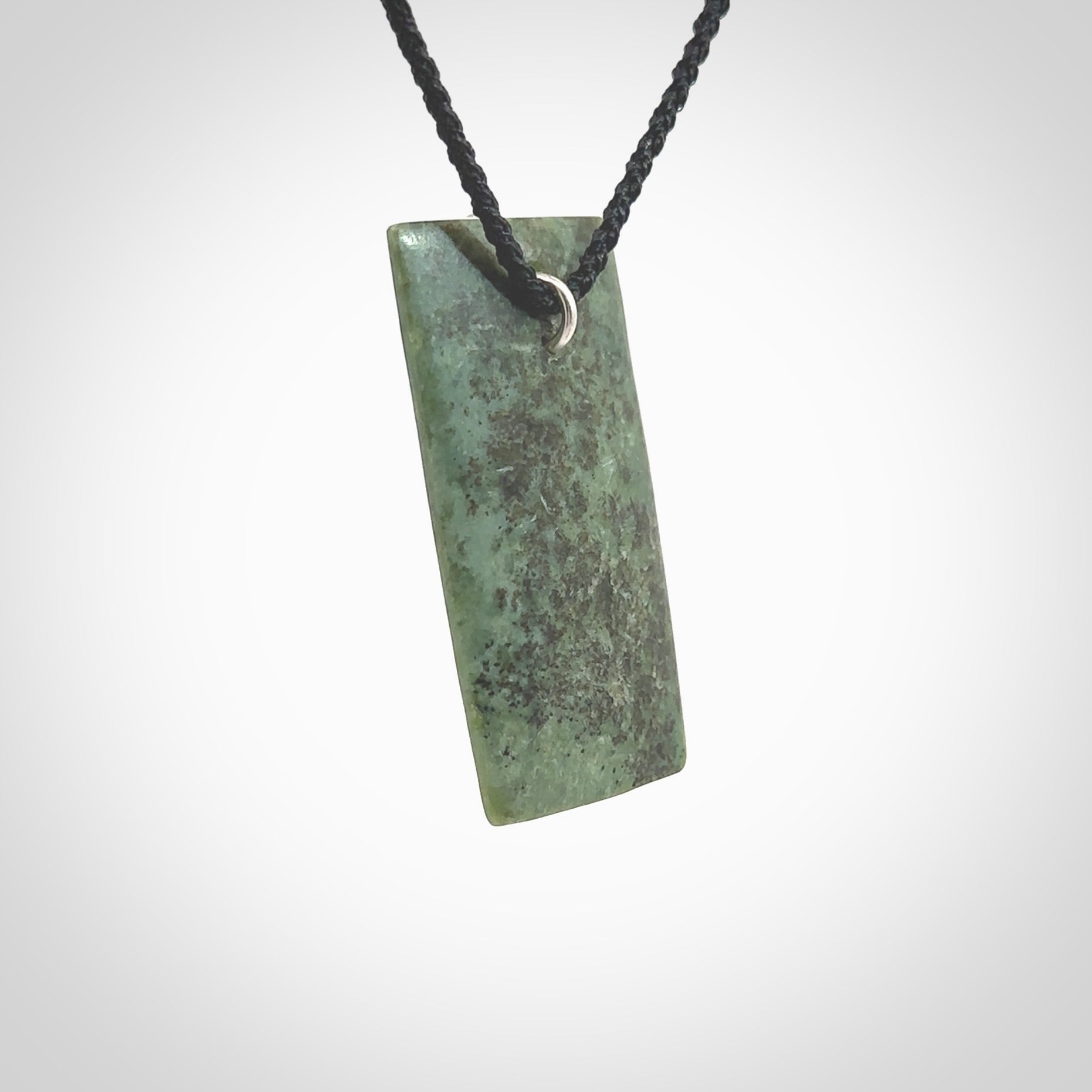 A charismatic pendant carved from New Zealand Pounamu. This is a medium sized, rectangle drop with a silver cast shard inlay on the front. Hand made by wonderful artist and carver; Ana Krakosky.