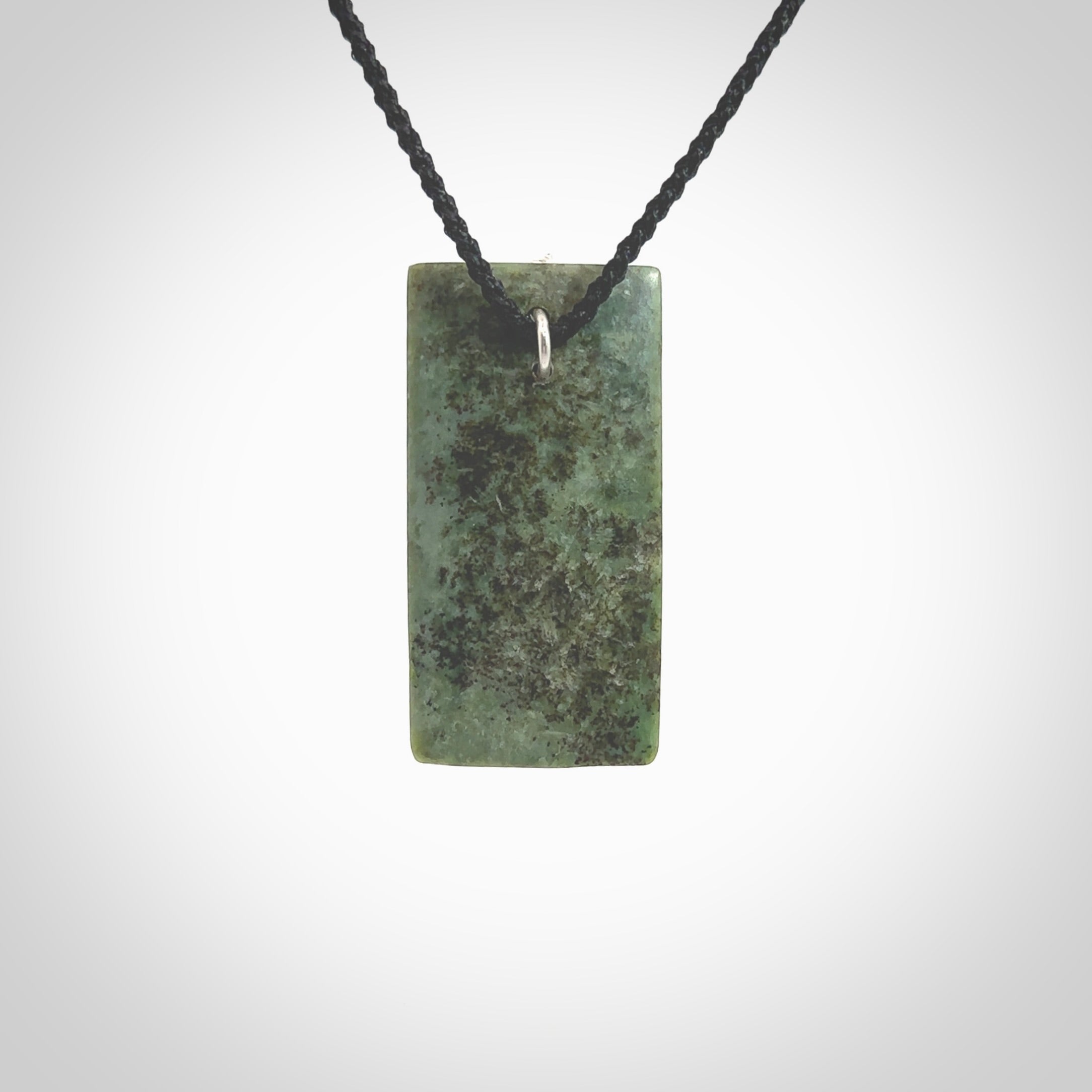 A charismatic pendant carved from New Zealand Pounamu. This is a medium sized, rectangle drop with a silver cast shard inlay on the front. Hand made by wonderful artist and carver; Ana Krakosky.