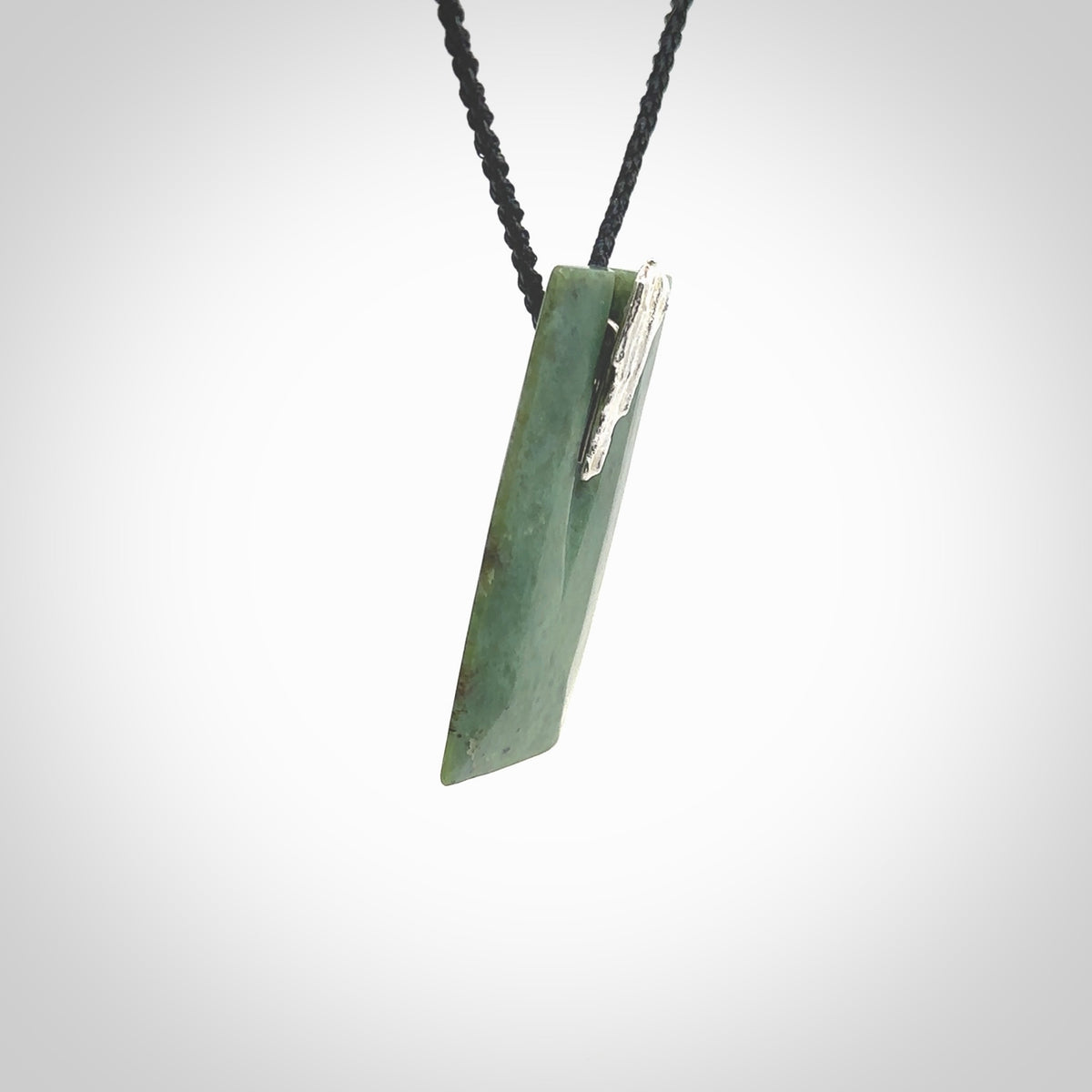 A charismatic pendant carved from New Zealand Pounamu. This is a medium sized, rectangle drop with a silver cast shard inlay on the front. Hand made by wonderful artist and carver; Ana Krakosky.