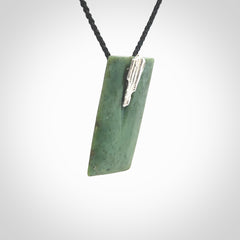 A charismatic pendant carved from New Zealand Pounamu. This is a medium sized, rectangle drop with a silver cast shard inlay on the front. Hand made by wonderful artist and carver; Ana Krakosky.