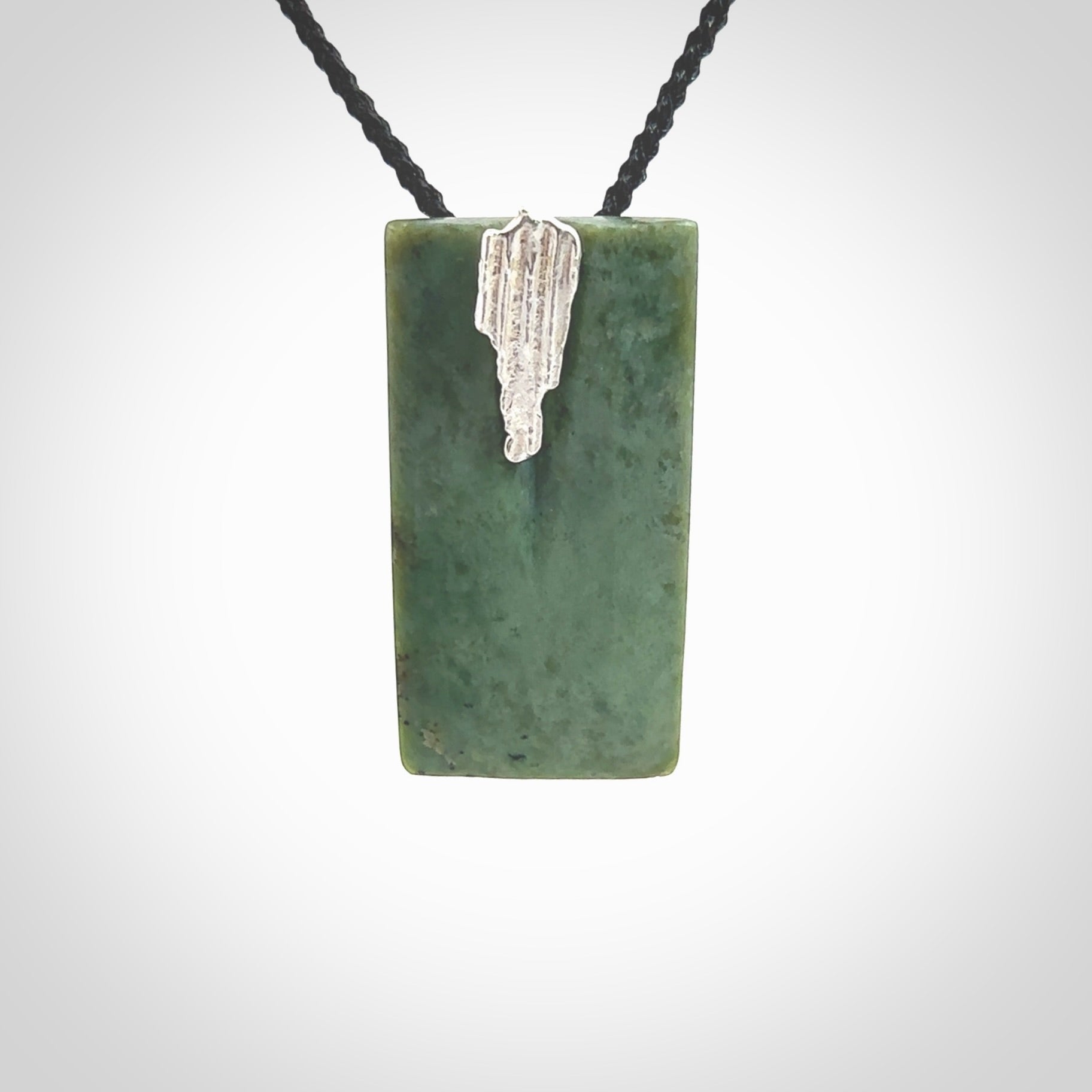 A charismatic pendant carved from New Zealand Pounamu. This is a medium sized, rectangle drop with a silver cast shard inlay on the front. Hand made by wonderful artist and carver; Ana Krakosky.