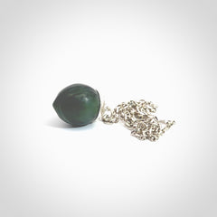 This picture shows a little jade acorn pendant with sterling silver chain. The cap is sterling silver and is embossed with some decorative markings which give the silver cap some detail and character. Hand made by Ana Krakosky.