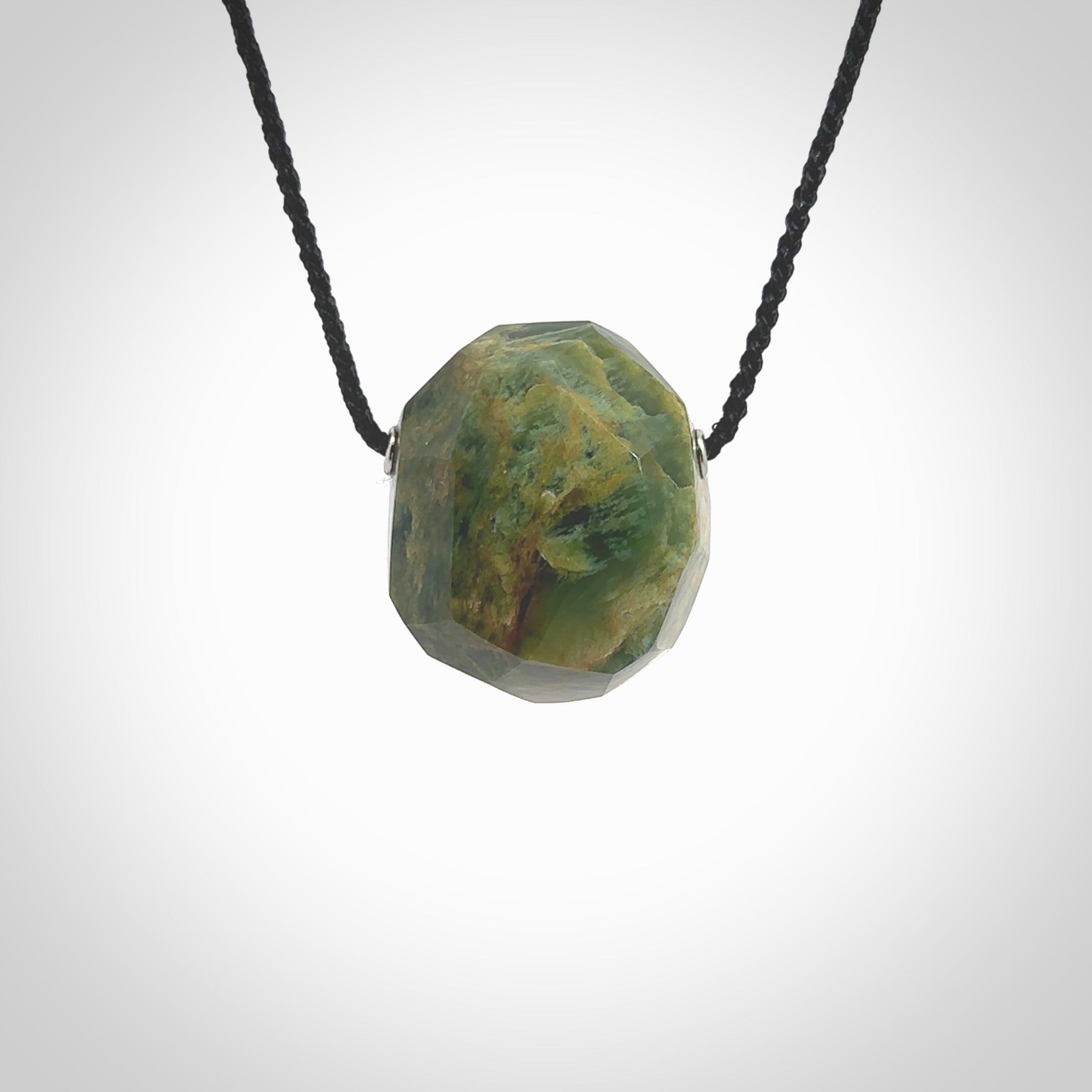 Hand carved large New Zealand flower Jade facet drop pendant. Made by Ana Krakosky for NZ Pacific in New Zealand Pounamu, jade. A beautiful orange and green marsden flower jade large facet drop necklace with black adjustable cord.