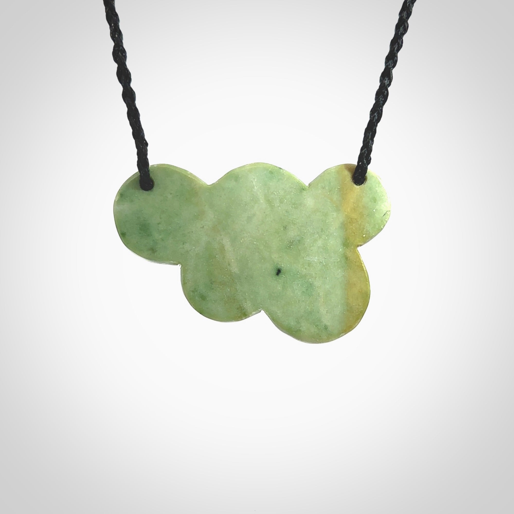 Hand carved New Zealand Jade bubbles drop pendant. Made by Ana Krakosky for NZ Pacific in New Zealand Pounamu, jade. A beautiful light and dark green jade drop of bubbles necklace with black adjustable cord.