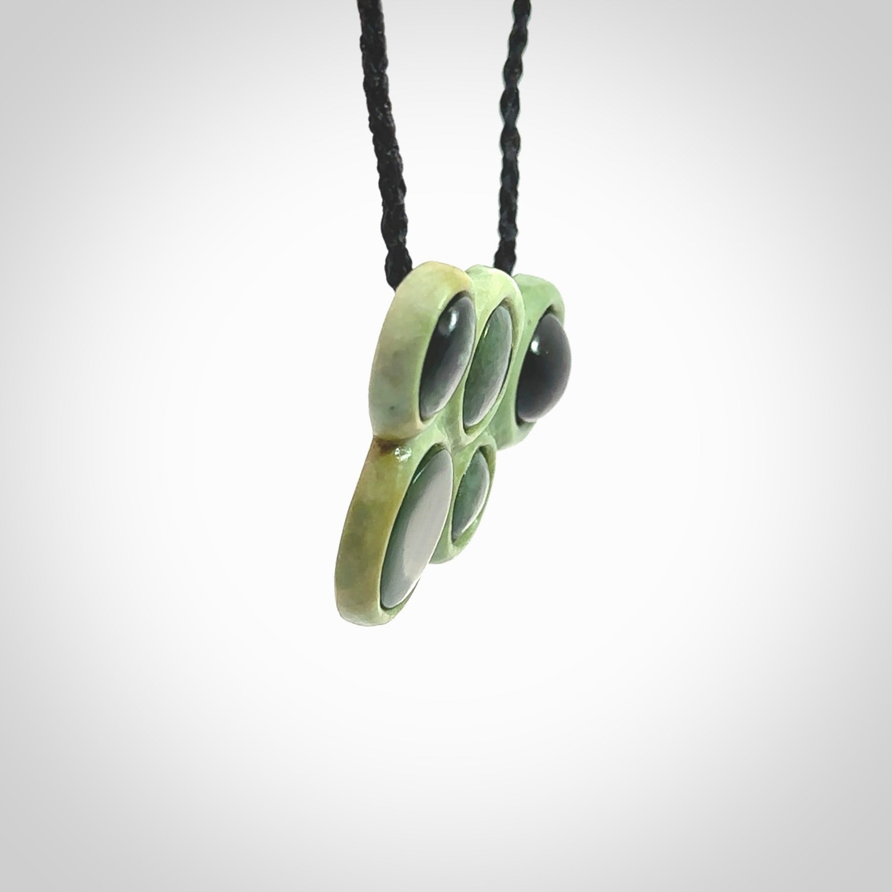 Hand carved New Zealand Jade bubbles drop pendant. Made by Ana Krakosky for NZ Pacific in New Zealand Pounamu, jade. A beautiful light and dark green jade drop of bubbles necklace with black adjustable cord.