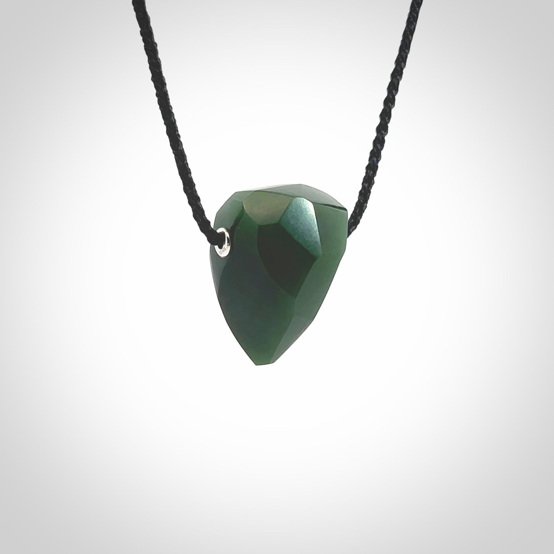 Hand carved New Zealand Jade facet drop pendant. Made by Ana Krakosky for NZ Pacific in New Zealand Pounamu, jade. A beautiful green marsden jade facet drop necklace with black adjustable cord.