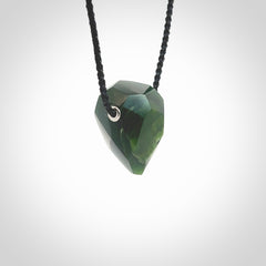 Hand carved New Zealand Jade facet drop pendant. Made by Ana Krakosky for NZ Pacific in New Zealand Pounamu, jade. A beautiful green marsden jade facet drop necklace with black adjustable cord.