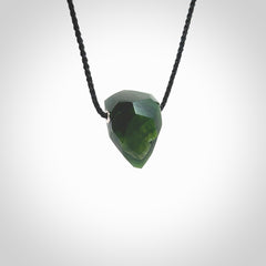 Hand carved New Zealand Jade facet drop pendant. Made by Ana Krakosky for NZ Pacific in New Zealand Pounamu, jade. A beautiful green marsden jade facet drop necklace with black adjustable cord.