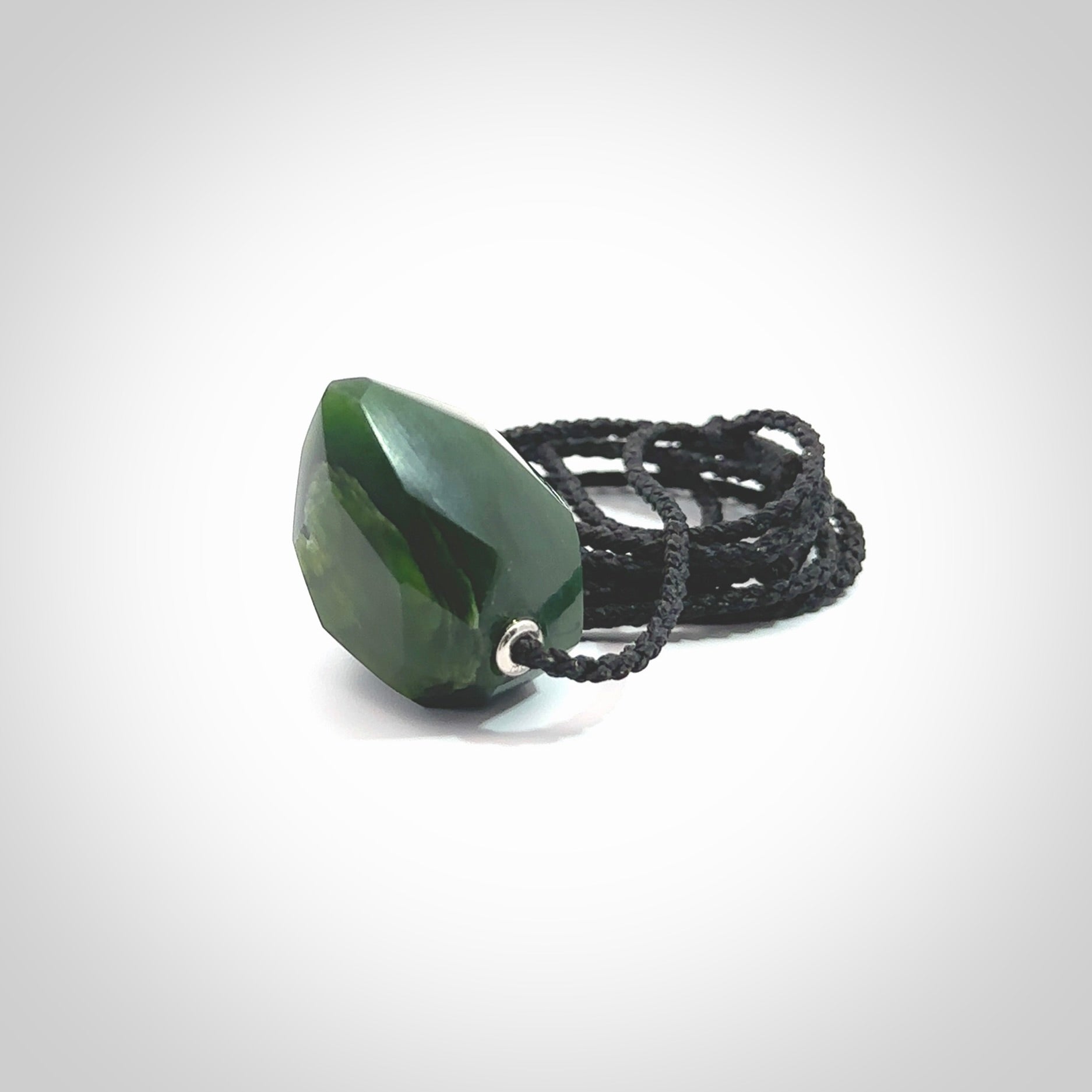 Hand carved New Zealand Jade facet drop pendant. Made by Ana Krakosky for NZ Pacific in New Zealand Pounamu, jade. A beautiful green marsden jade facet drop necklace with black adjustable cord.