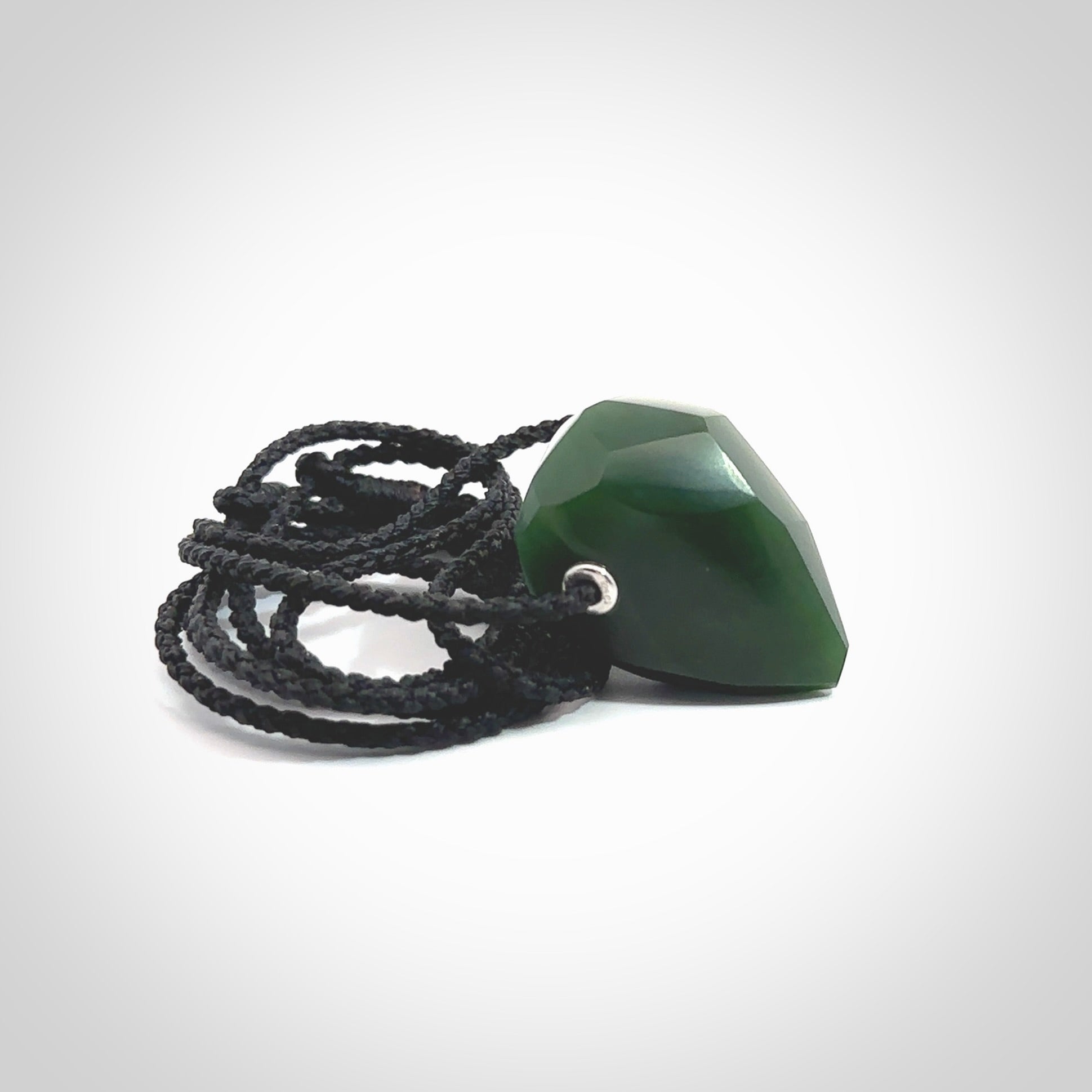 Hand carved New Zealand Jade facet drop pendant. Made by Ana Krakosky for NZ Pacific in New Zealand Pounamu, jade. A beautiful green marsden jade facet drop necklace with black adjustable cord.