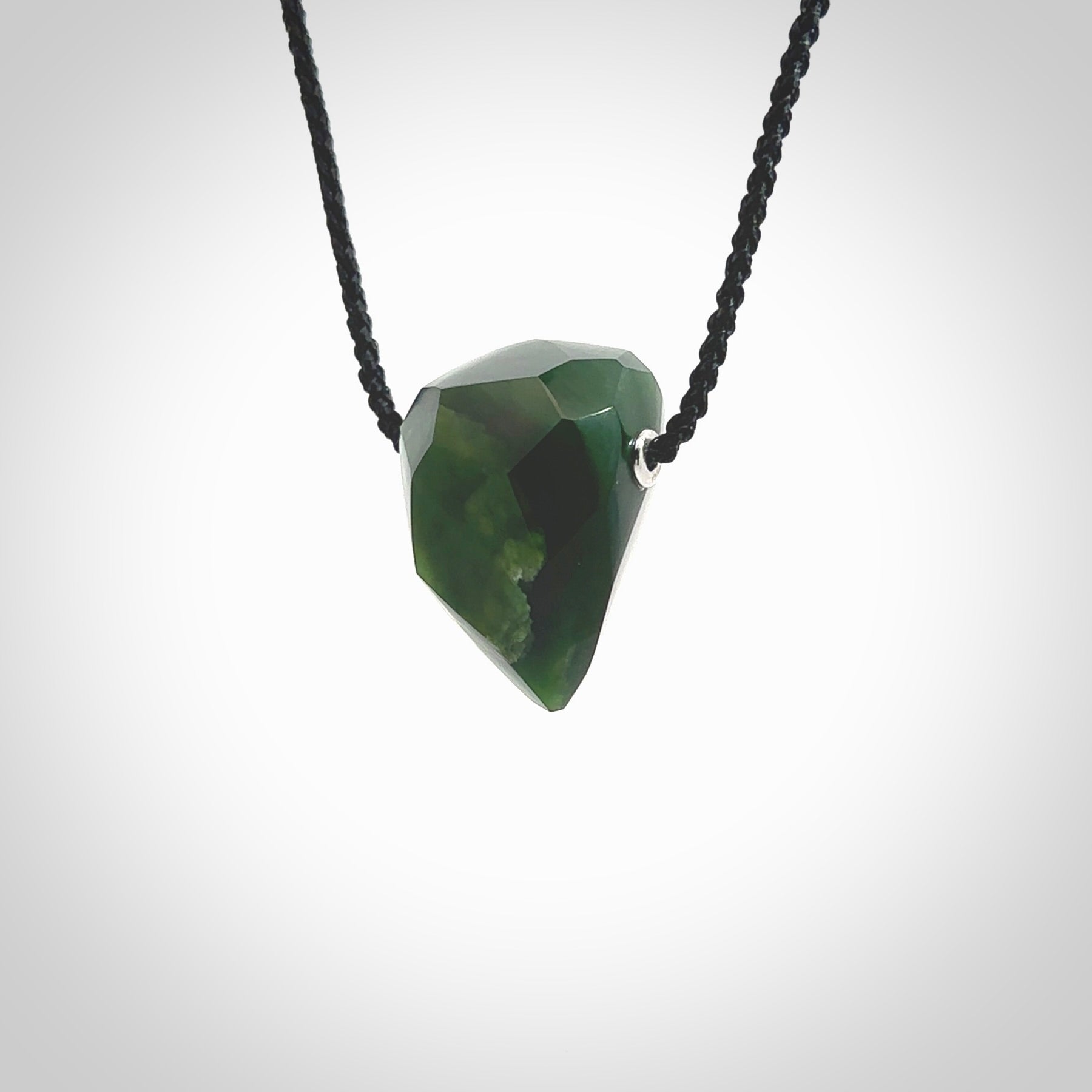 Hand carved New Zealand Jade facet drop pendant. Made by Ana Krakosky for NZ Pacific in New Zealand Pounamu, jade. A beautiful green marsden jade facet drop necklace with black adjustable cord.