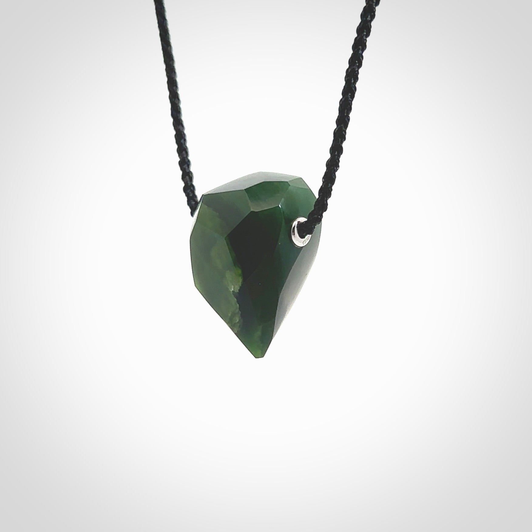 Hand carved New Zealand Jade facet drop pendant. Made by Ana Krakosky for NZ Pacific in New Zealand Pounamu, jade. A beautiful green marsden jade facet drop necklace with black adjustable cord.