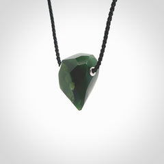 Hand carved New Zealand Jade facet drop pendant. Made by Ana Krakosky for NZ Pacific in New Zealand Pounamu, jade. A beautiful green marsden jade facet drop necklace with black adjustable cord.