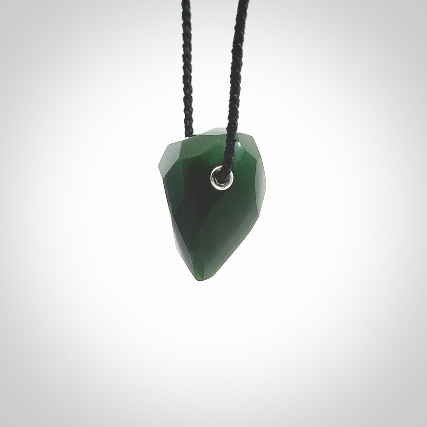 Hand carved New Zealand Jade facet drop pendant. Made by Ana Krakosky for NZ Pacific in New Zealand Pounamu, jade. A beautiful green marsden jade facet drop necklace with black adjustable cord.