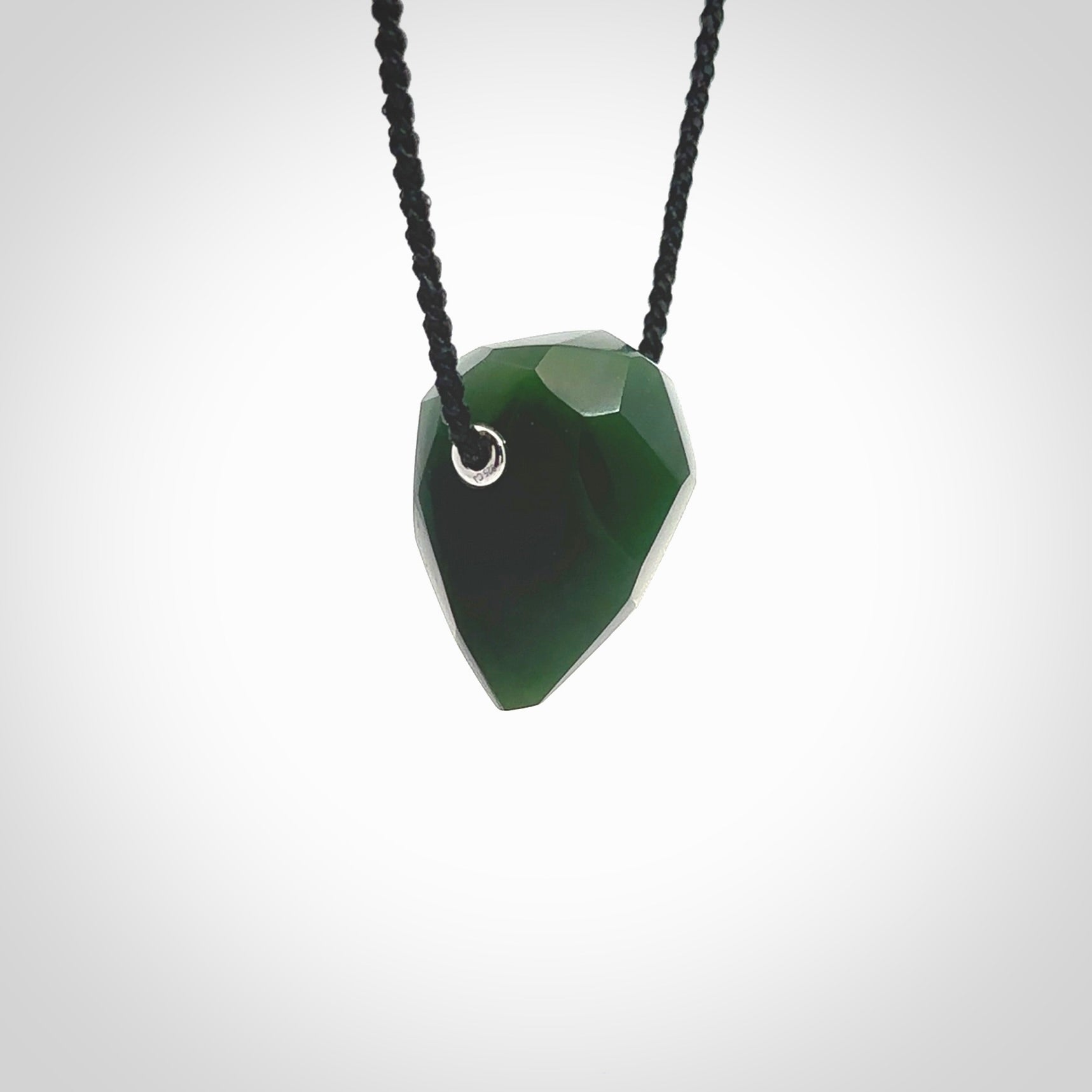 Hand carved New Zealand Jade facet drop pendant. Made by Ana Krakosky for NZ Pacific in New Zealand Pounamu, jade. A beautiful green marsden jade facet drop necklace with black adjustable cord.